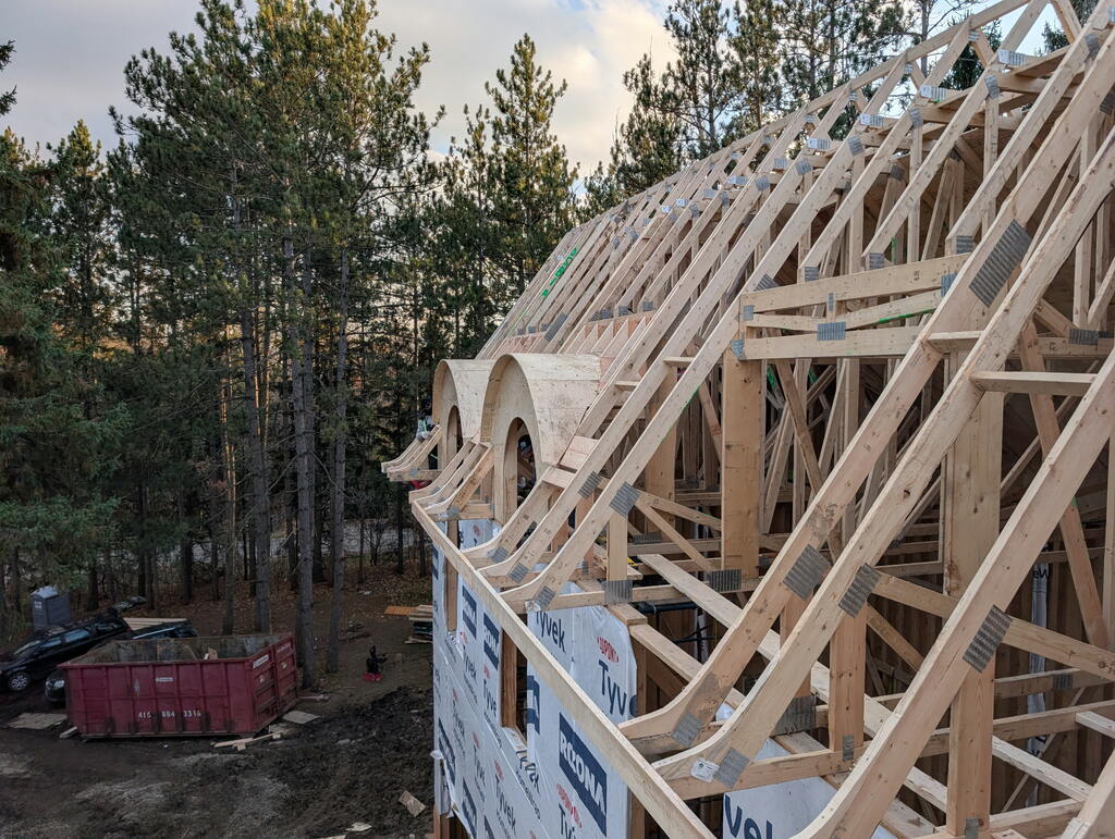Custom framers are finishing a pitched roof with custom barrel dormers as a luxury detail.