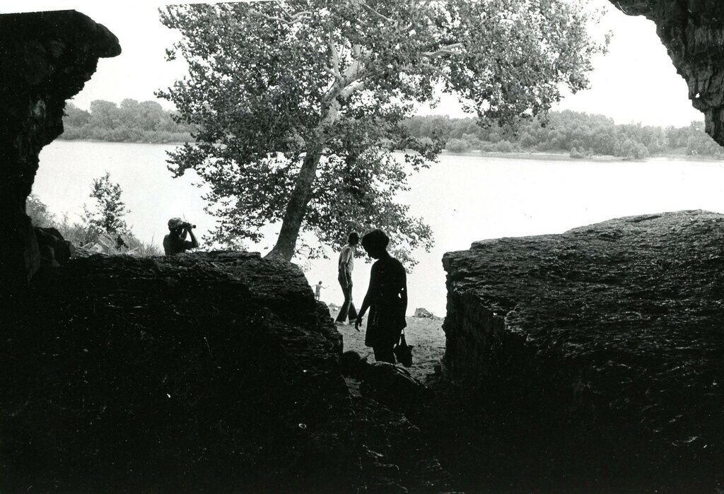 silhouette of sight seers taken from inside a cave